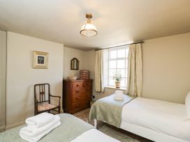 A bedroom with two beds and a dresser at Mallards in Bourton-On-The-Water