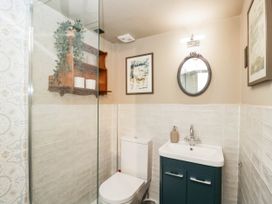 A bathroom with a shower, toilet, and sink at Mallards in Bourton-On-The-Water