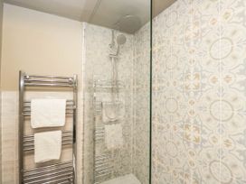 A bathroom with a shower and towel rack at Mallards in Bourton-On-The-Water