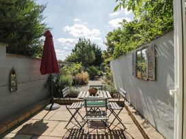 A garden with a table and chairs under an umbrella at Mallards in Bourton-On-The-Water