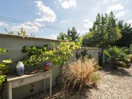 A garden with a table and plants at Mallards in Bourton-On-The-Water