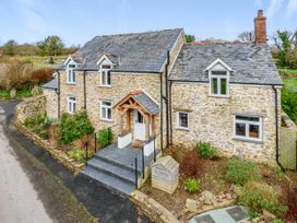 A house with stone walls and a front porch at Middle Dean Farmhouse in Trentishoe near Parracombe