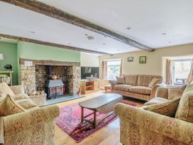 A living room with a fireplace and sofa at Middle Dean Farmhouse Trentishoe near Parracombe