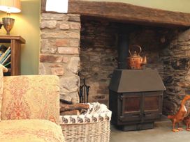 A living room with a fireplace and a sofa at Middle Dean Farmhouse in Trentishoe near Parracombe