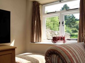 A living room with a television and toy tractor at Middle Dean Farmhouse, Trentishoe near Parracombe