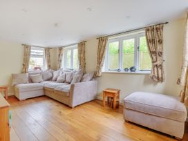 A living room with a sofa and windows at Middle Dean Farmhouse in Trentishoe near Parracombe