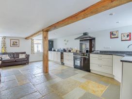 A kitchen with cabinets and a sofa at Middle Dean Farmhouse near Trentishoe