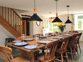 A dining room with a long table set for a meal at Middle Dean Farmhouse in Trentishoe near Parracombe