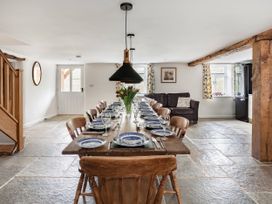 A dining room with a large table set for dinner at Middle Dean Farmhouse Trentishoe near Parracombe
