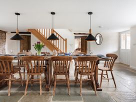 A dining room with a long table and chairs at Middle Dean Farmhouse in Trentishoe near Parracombe