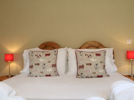 A bedroom with a double bed and decorative pillows at Middle Dean Farmhouse near Parracombe