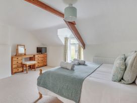 A bedroom with a bed and dresser at Middle Dean Farmhouse, Trentishoe near Parracombe