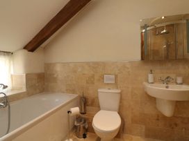 A bathroom with a bathtub, toilet, and sink at Middle Dean Farmhouse, Trentishoe near Parracombe