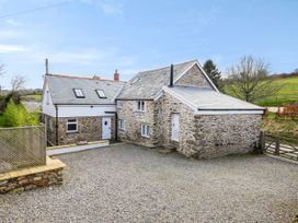 A house with a stone exterior and a gravel driveway at Middle Dean Farmhouse near Trentishoe