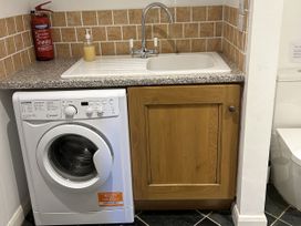 A laundry room with a washing machine and sink at Middle Dean Farmhouse Trentishoe near Parracombe