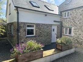 A house with a stone exterior and flowers in planters at Middle Dean Farmhouse, Trentishoe near Parracombe