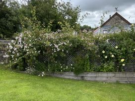 A garden with flowers and a wooden fence at Middle Dean Farmhouse in Trentishoe near Parracombe