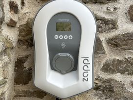 An electric vehicle charger mounted on a stone wall at Middle Dean Farmhouse near Trentishoe Parracombe