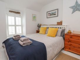 A bedroom with a bed and dresser at Menuchah in Criccieth