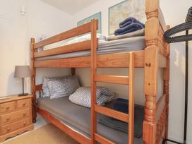 A bedroom with a bunk bed and bedside lamp at Menuchah in Criccieth