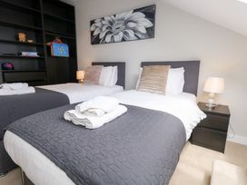 A bedroom with two beds and a bookshelf at Durbyfield in Nottington near Weymouth