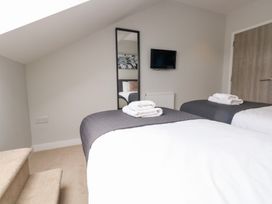 A bedroom with two beds and a TV at Durbyfield in Nottington near Weymouth