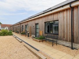 An outdoor area with a wooden building and benches at Durbyfield Nottington near Weymouth