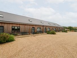 An outdoor area with a building featuring windows and doors at Lulstead Nottington near Weymouth