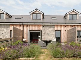 A garden with a table and chairs in front of a building at Lulstead in Nottington near Weymouth