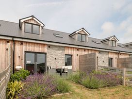 An outdoor area with a house featuring a stone wall and seating at Lulstead Nottington near Weymouth