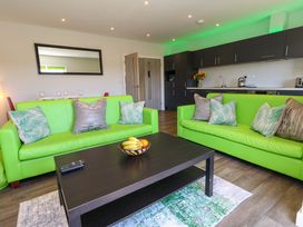 A living room with green couches and a coffee table at Overcombe Mill Nottington near Weymouth