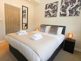 A bedroom with a double bed and artworks on wall at Overcombe Mill Nottington near Weymouth