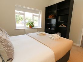 A bedroom with a bed and shelves at Overcombe Mill in Nottington near Weymouth