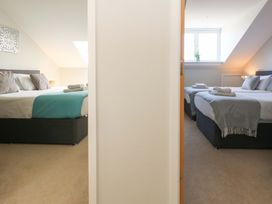 A bedroom with two beds and a window at Overcombe Mill in Nottington near Weymouth