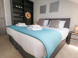 A bedroom with a bed and shelves at Overcombe Mill, Nottington near Weymouth