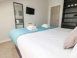 A bedroom with a double bed and a mirror at Overcombe Mill in Nottington near Weymouth