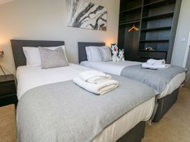 A bedroom with two beds and a shelf at Overcombe Mill in Nottington near Weymouth