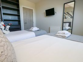 A bedroom with two beds and a mirror at Overcombe Mill in Nottington near Weymouth