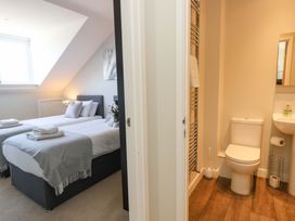 A bedroom with two beds and an adjacent bathroom at Overcombe Mill Nottington near Weymouth