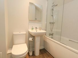 A bathroom with a toilet, sink, bath, and shower at Overcombe Mill in Nottington near Weymouth