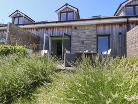 An outdoor area with a table and chairs in front of a wooden building at Overcombe Mill Nottington near Weymouth