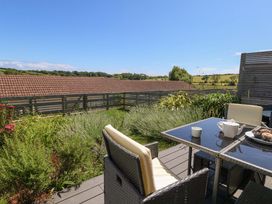 A patio area with a table and chairs at Overcombe Mill in Nottington near Weymouth
