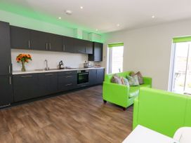 A kitchen with a sink and green couch at Overcombe Mill in Nottington near Weymouth