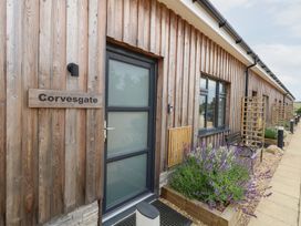 An outdoor entry area with a wooden exterior and a plant bed at Corvesgate in Nottington near Weymouth