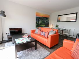 A living room with sofas, a coffee table, and a dining area at Corvesgate in Nottington near Weymouth