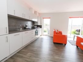A kitchen with appliances and seating area at Corvesgate Nottington near Weymouth