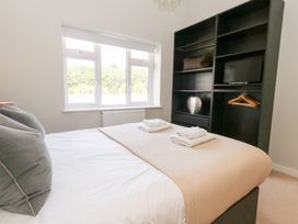 A bedroom with a bed and shelf unit at Corvesgate in Nottington near Weymouth