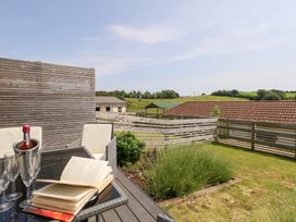 An outdoor seating area with a bottle and glasses at Corvesgate in Nottington near Weymouth