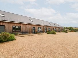 An outdoor view of a wooden building with gravel pathway at Corvesgate Nottington near Weymouth