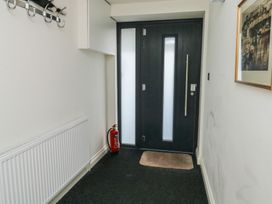 A hallway with a front door and coat hooks at Bay View in Brixham